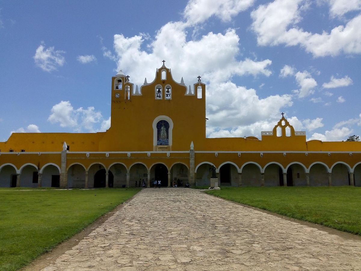 Yellow Franciscan convent of San Antonio de Padua in Izamal, seen across its grassy atrium